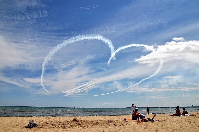 Airplanes draw heart in the sky and fighter jets fly through it
