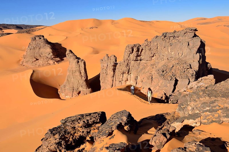 People hiking in the sand dunes and rocks of Moul Naga