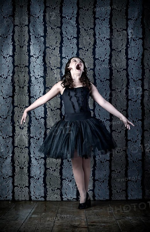 Girl wearing a black ballet dress screaming