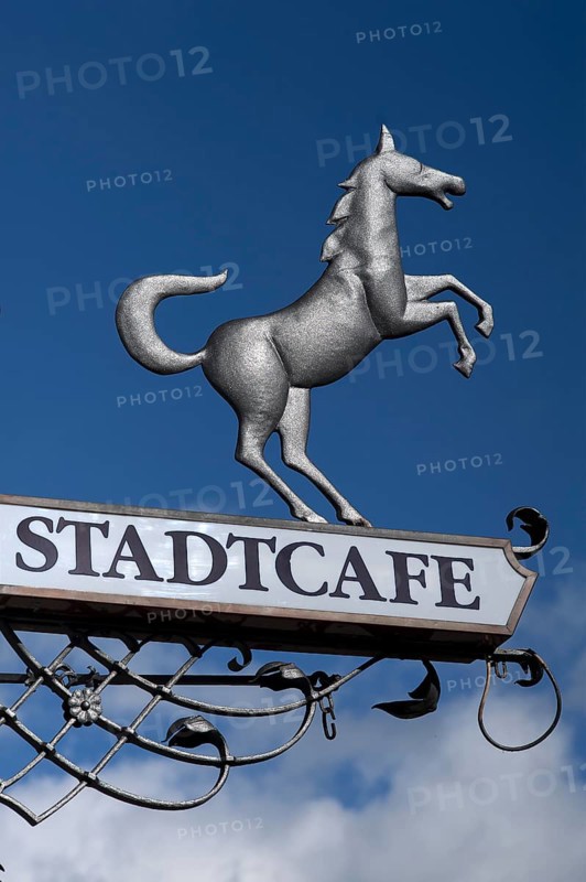 Hanging sign of 'Stadtcafe' against a blue sky
