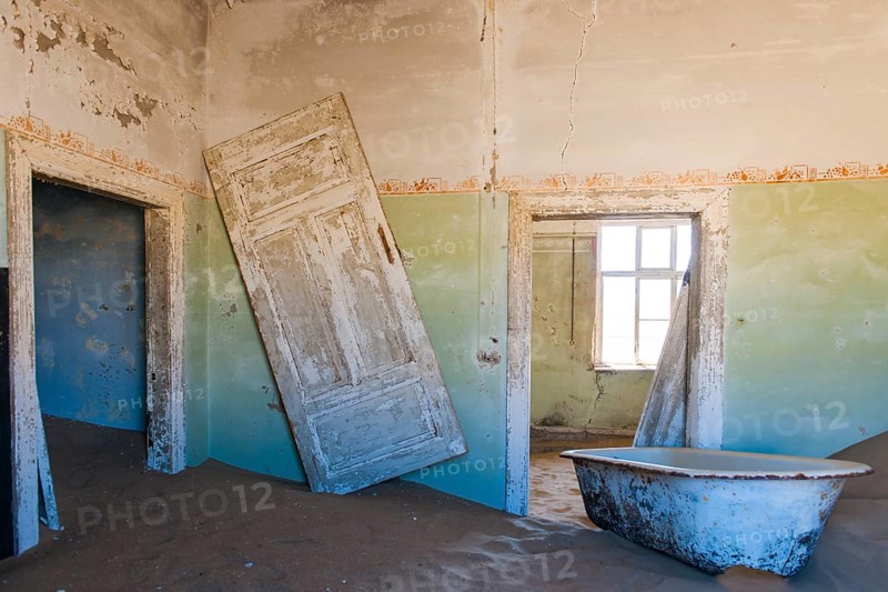 Wind-borne sand in a house of the former diamond miners settlement that is slowly covered by the sand of the Namib Desert
