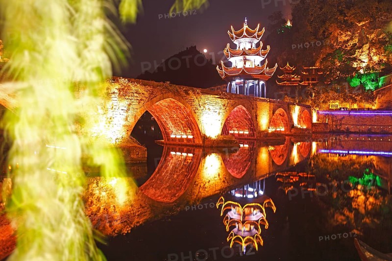 Colorfully illuminated stone bridge and the Kuixingge Pagoda at night