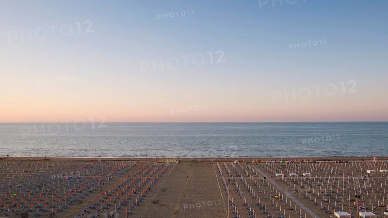 View of a beach with sunshades and sun beds