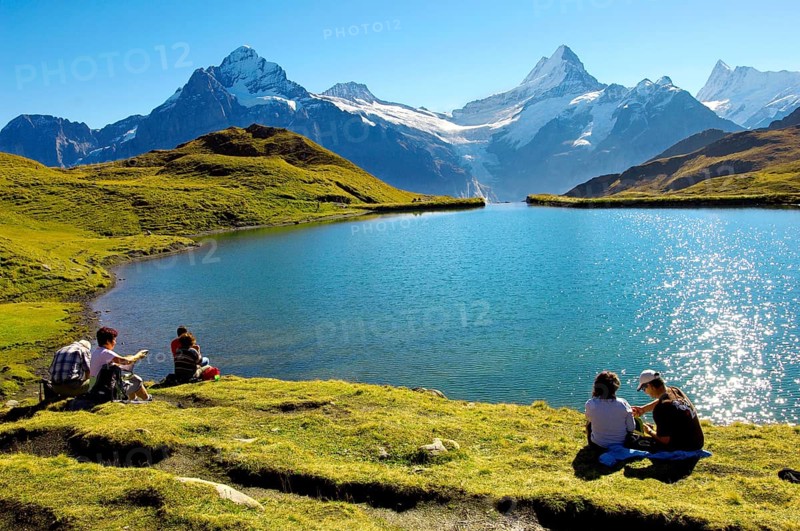 Walkers having a rest next to Bachalpsee lake near Grindelwald First