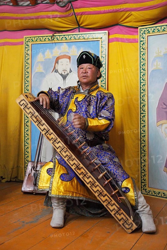 Man in the traditional costume of the Khalkha Mongols playing the Mongolian Zither