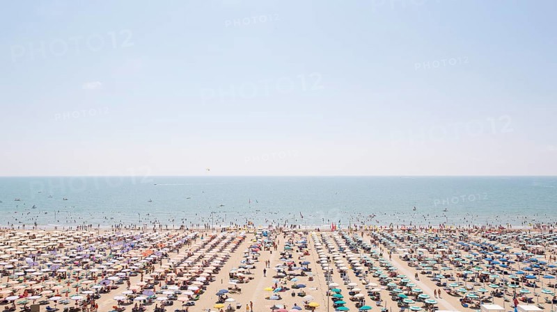 View of a beach with sunshades and sun beds