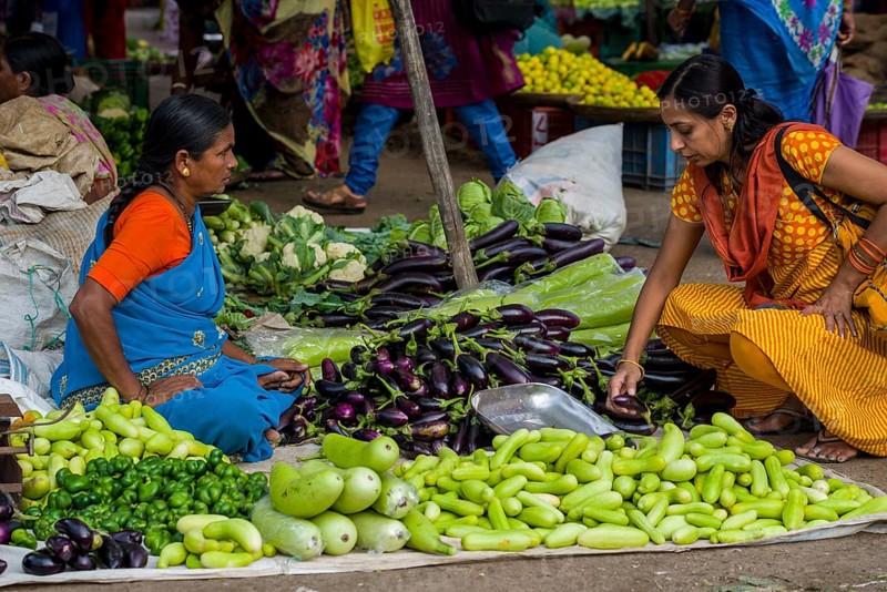 A woman is selling aubergines