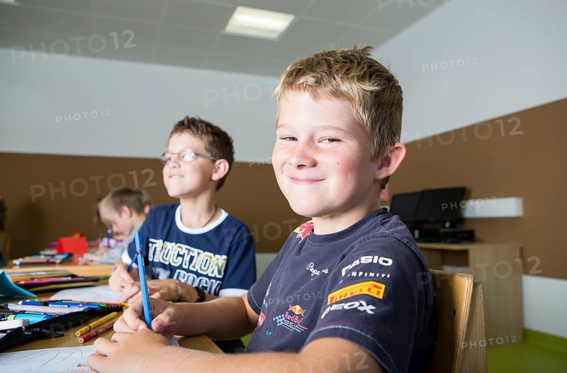 Children sitting in a primary school class during a drawing lesson