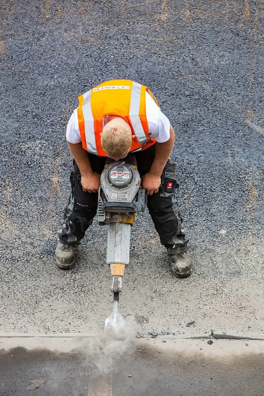 Road construction worker operating a pneumatic drill