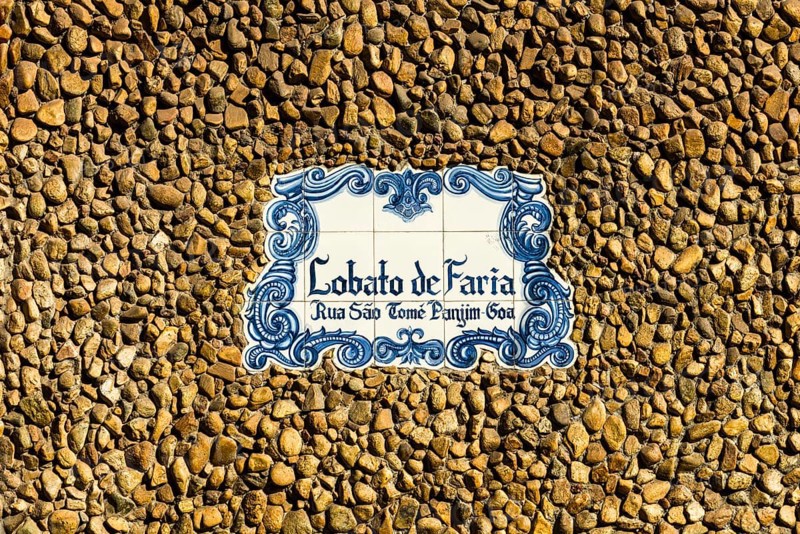 A blue and white plate with the name of the house at the entrance of a building