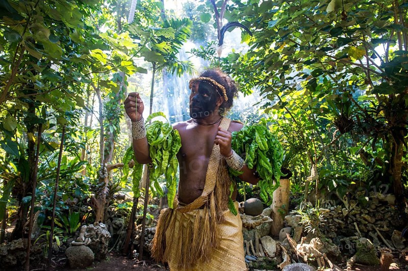 Traditional dressed man with black face in the jungle