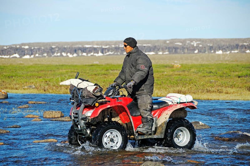 Man of the Inuit people riding a quad bike