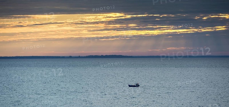 Fishing boat on the Curonian Lagoon at sunrise