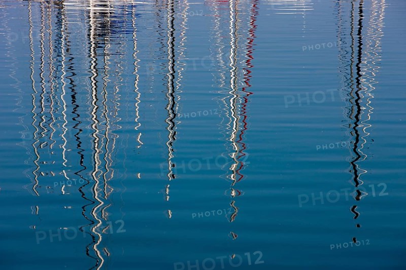 Boat masts reflecting in the sea