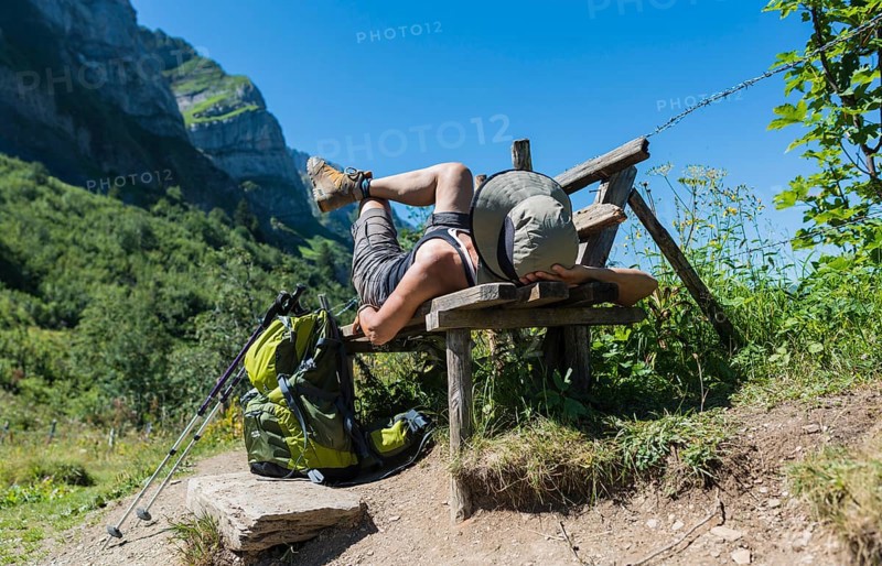 Female hiker lying on a bench
