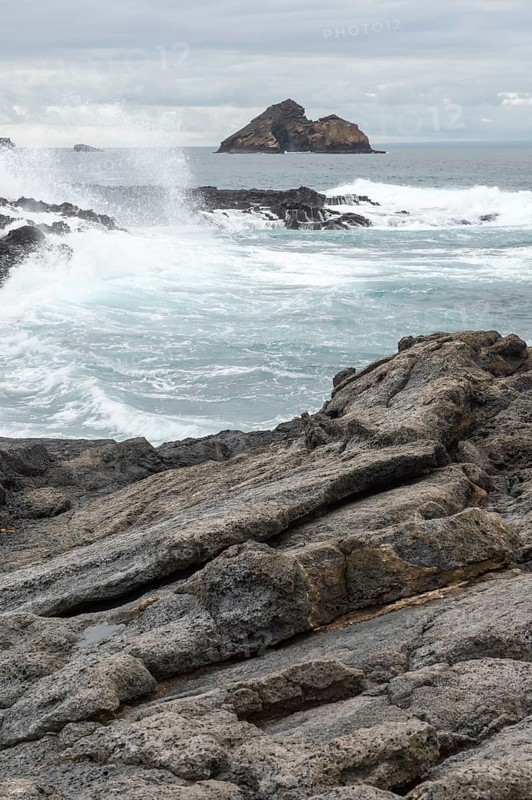 Waves breaking on the coast of Chinaman's Hat island off Santiago Island