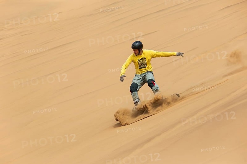 Sand boarding in the dunes of the Namib Desert