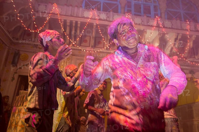 Devotees covered in coloured powder celebrating