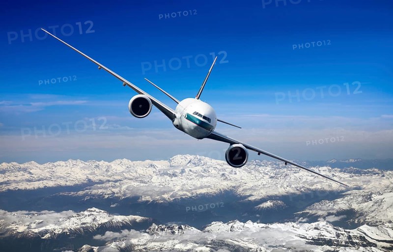 Cathay Pacific Boeing 777-367 ER in flight over mountains