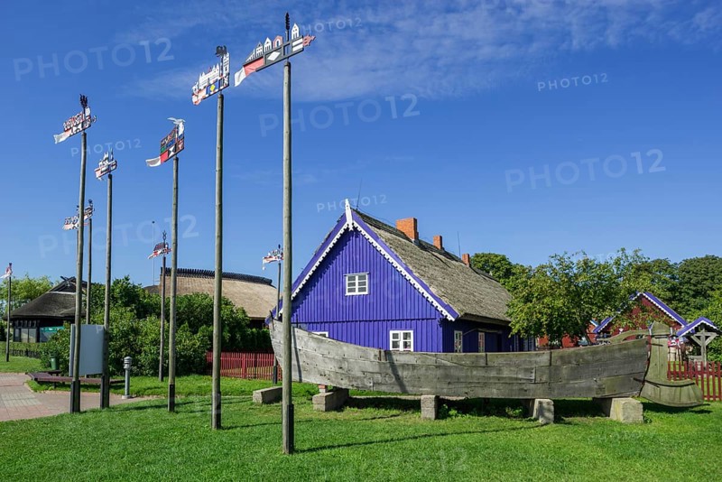 Curonian flags in front of traditional wooden houses