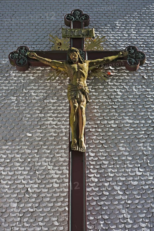Carved wooden crucifix on the shingle facade of the parish church of St. Margaret