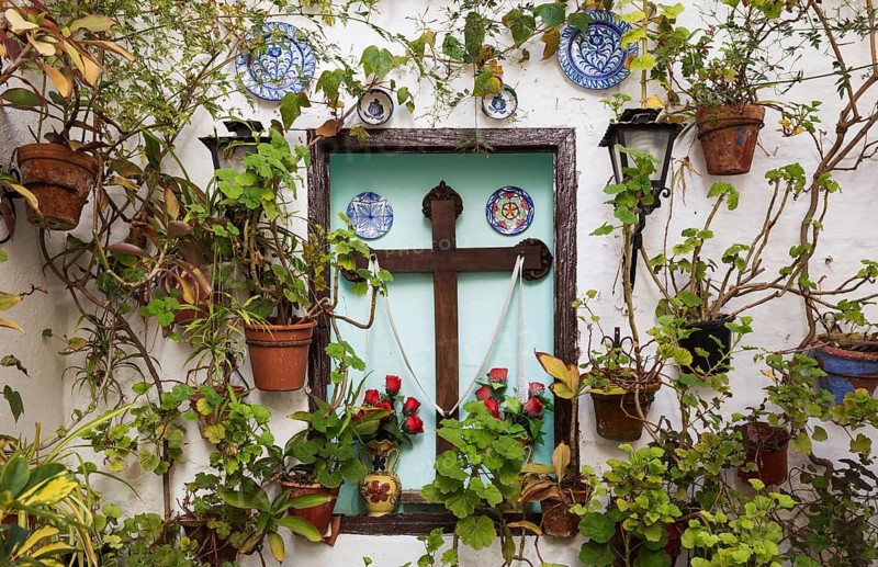 Corner with many potted plants and a cross