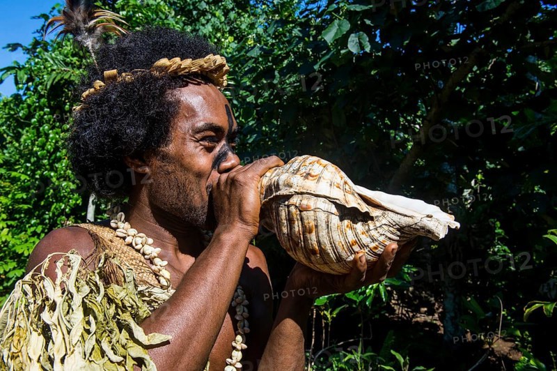 Man blowing in a giant shell