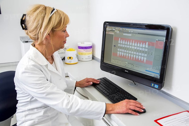 Dental assistant entering a patient's data into the electronic medical record