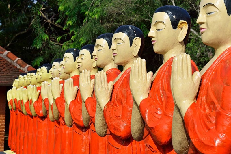 Figures of Buddhist monks in front of a monastery