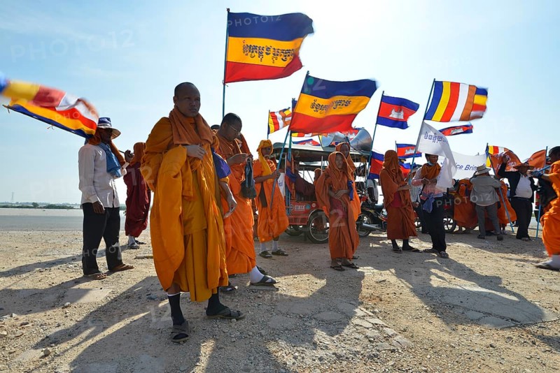 Cambodian monks and novices at a protest with Buddhist flags and national flags of Cambodia