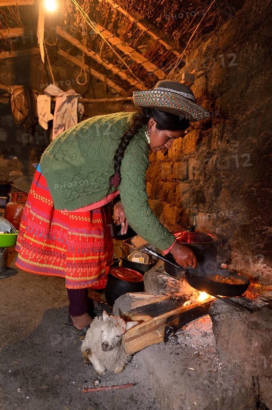 Young woman cooking on an open fire in her traditional kitchen