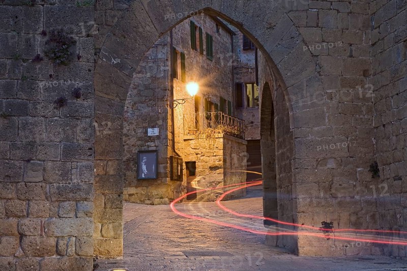City gate with the light trace of a passing car