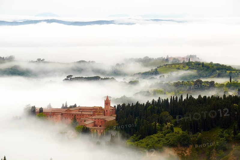Monte Oliveto Maggiore abbey with mist-shrouded valleys