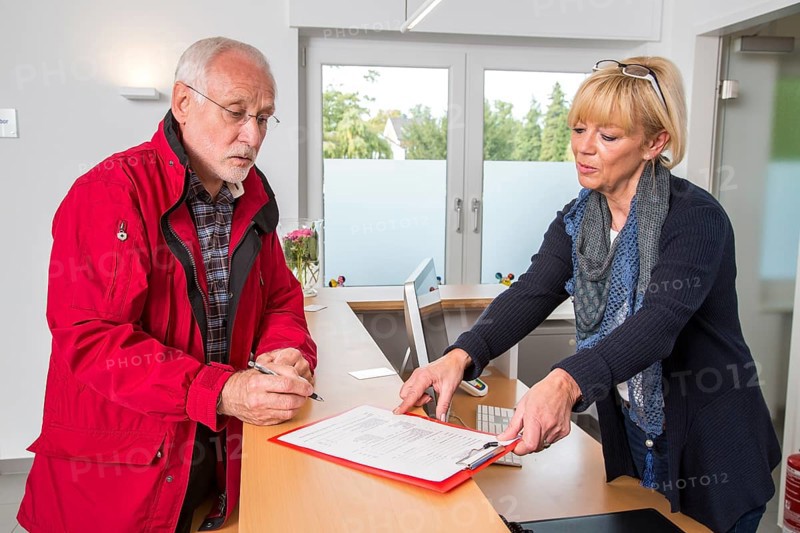 Patient filling in a form at the reception of a dental office