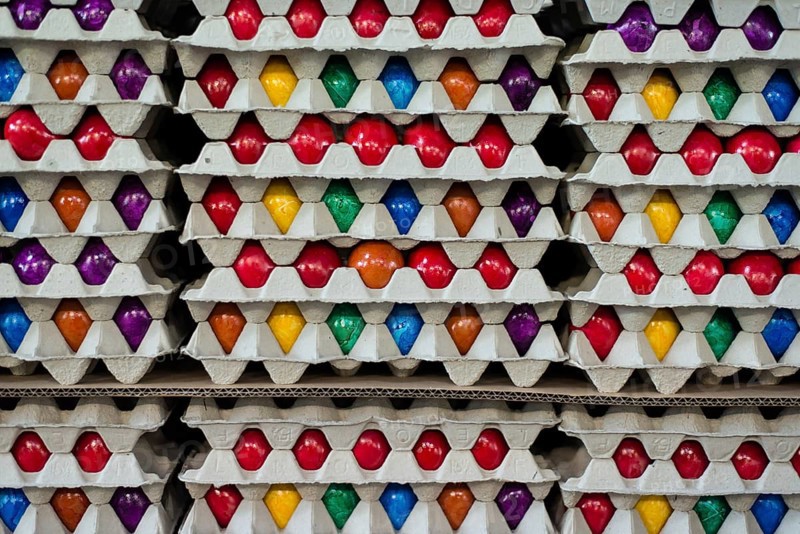 Brightly colored Easter eggs stacked in cardboard boxes