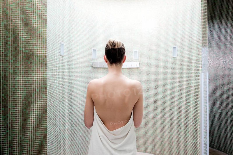 Woman standing in a steam room of a spa complex