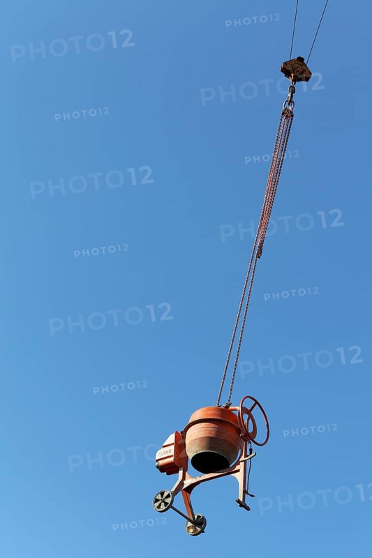 Concrete mixer hanging from a crane