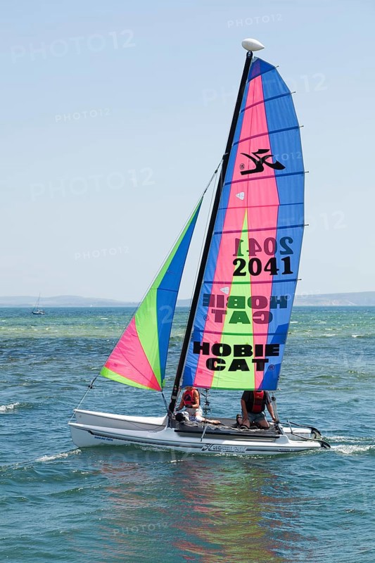 Two people sailing on a Hobie Cat catamaran