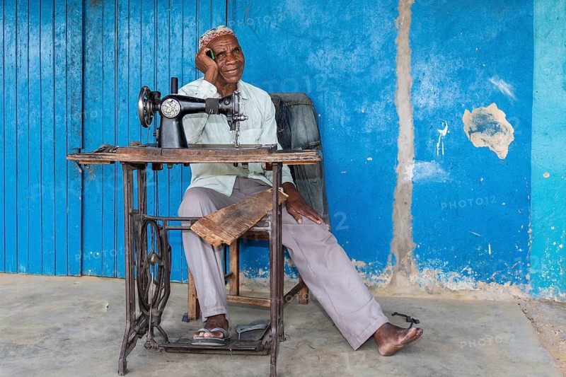 Tailor sitting in front of his shop in Kalabo