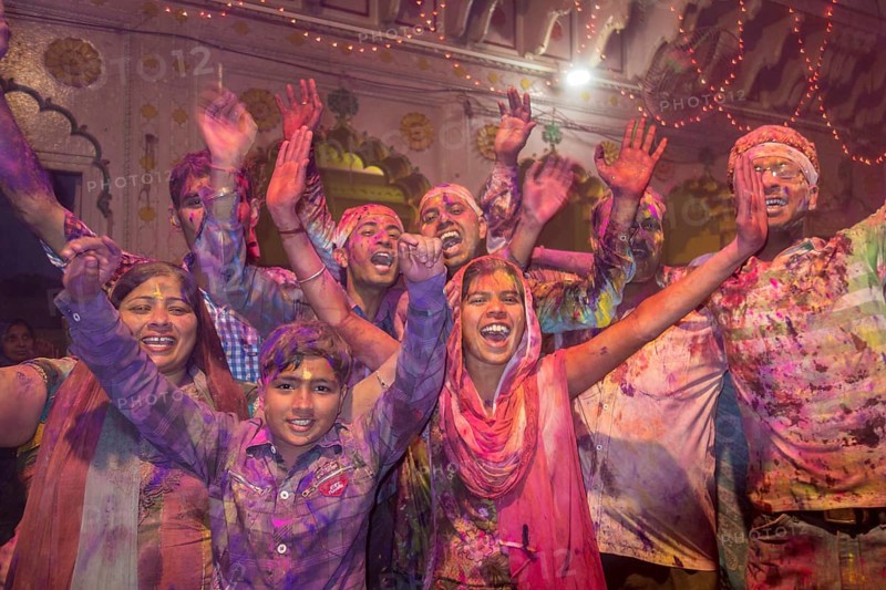 Devotees covered in coloured powder celebrating