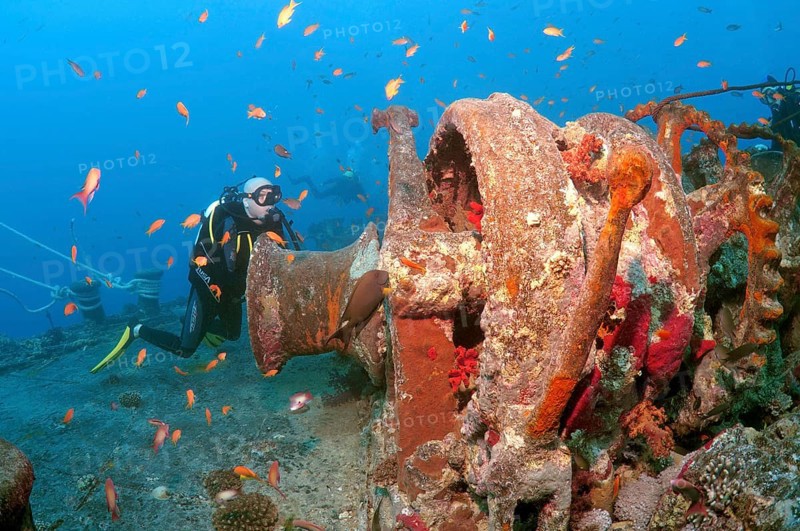 Scuba diver looking at winch of shipwreck 'SS Thistlegorm'