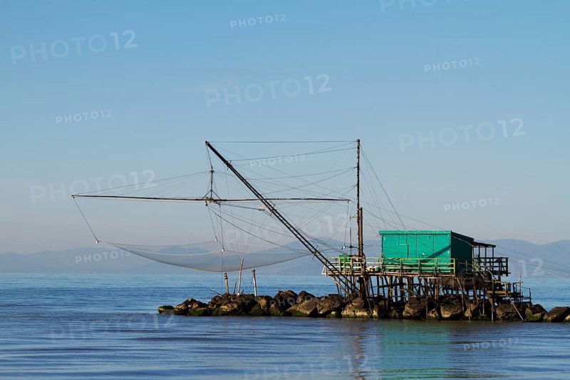 Fisherman's house with a net over the sea in Marina di Pisa