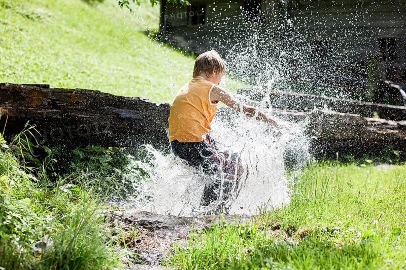Boy jumping into a stream