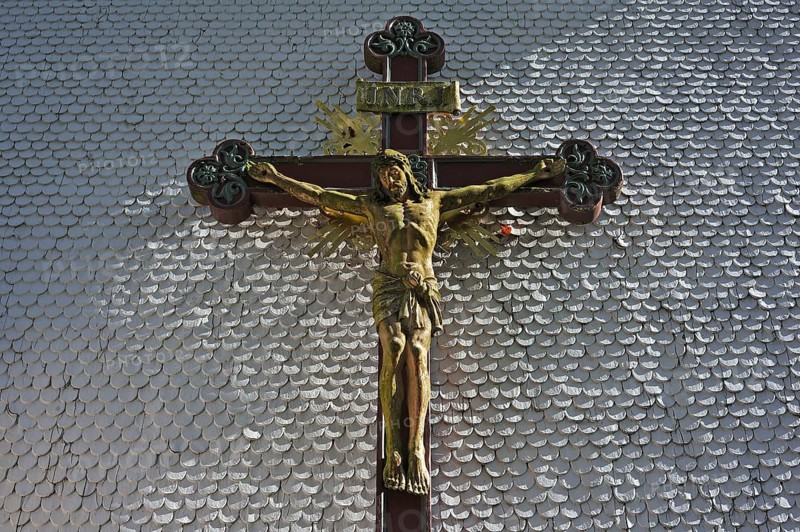 Carved wooden crucifix on the shingle facade of the parish church of St. Margaret