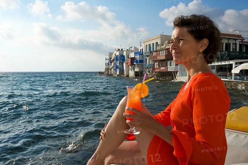 Woman enjoying a cocktail and a view over the sea