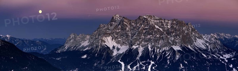 Summit of Mt Zugspitze with a full moon at dusk