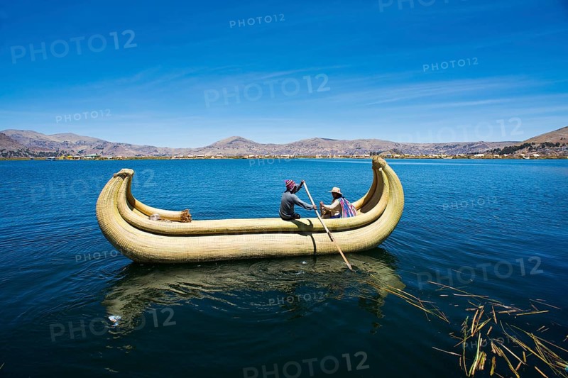 Two local in a traditional rowing boat of Totora reed on Lake Titicaca