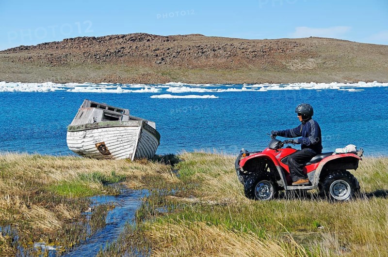Man of the Inuit people riding a quad bike