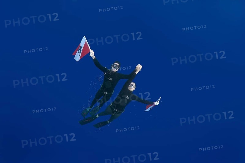 Freedivers holding a diver down flag