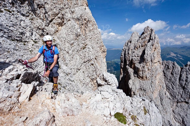 Mountain climber ascending Plattkofel mountain along the Oskar-Schuster Stieg climbing route